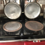 Aga hob with polished lids and a gleaming black enamel top after cleaning