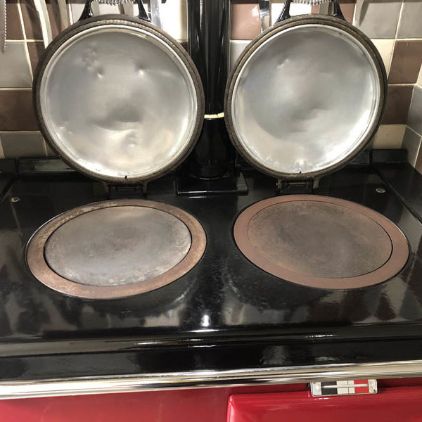 Aga hob with polished lids and a gleaming black enamel top after cleaning