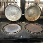 Aga hob with stained lids and burnt residue built up around both hotplate rims