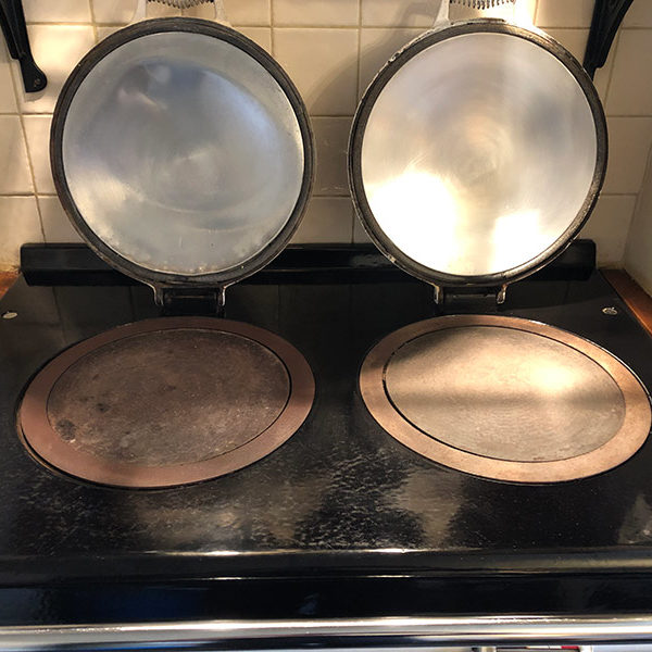 Aga hob with the left plate dull and stained and the right plate cleaned and polished