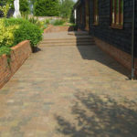 Same path cleaned to clear block paving with steps leading up to a garden