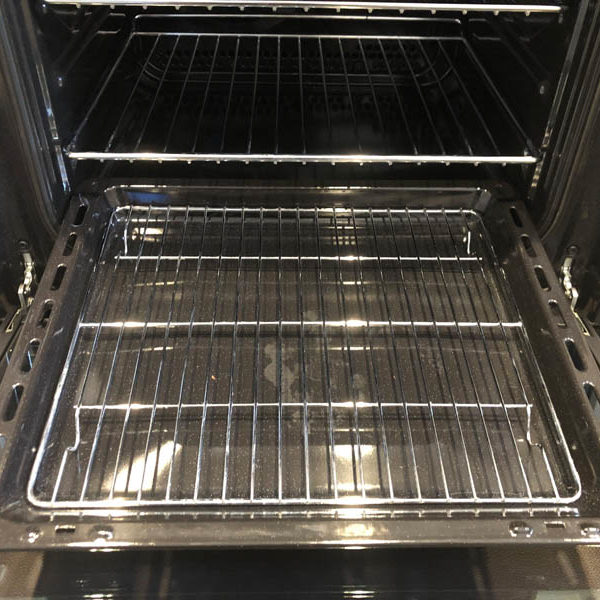 Clean grill pan and wire rack sitting in a spotless oven interior