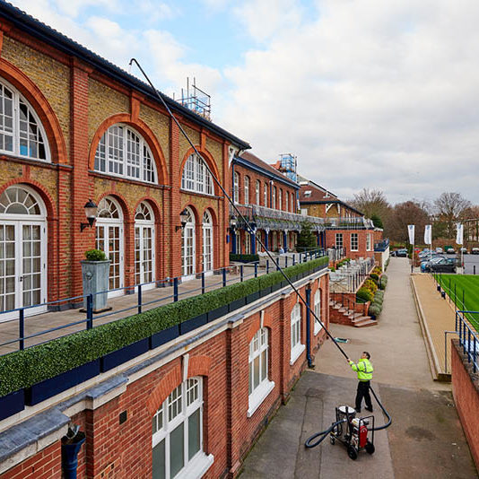 Operative clearing gutters on a large commercial terrace using a SkyVac suction pole
