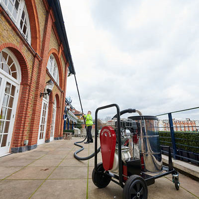 SkyVac Interceptor gutter vacuum in use outside a large commercial building